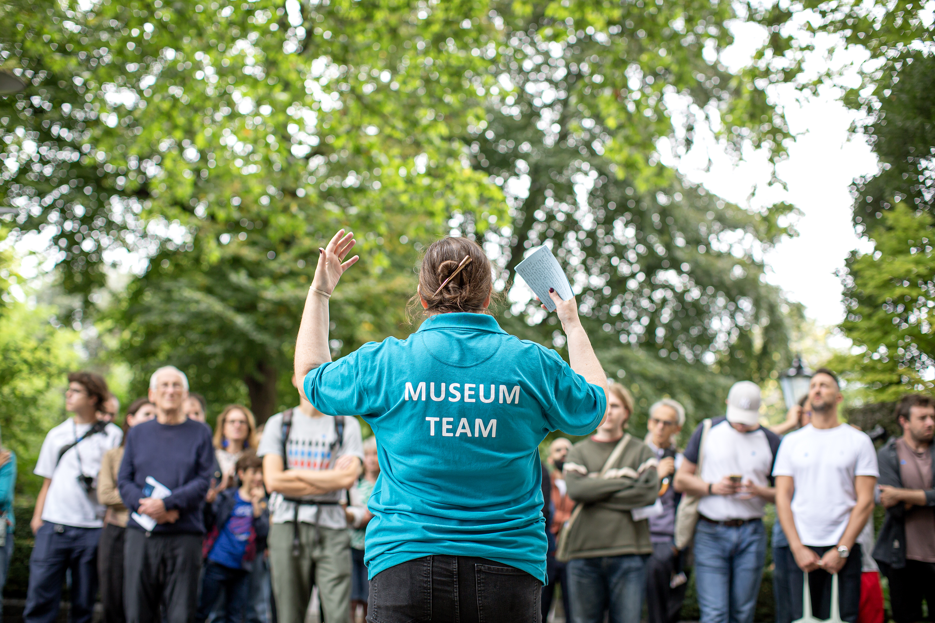 A tour guide gesturing as they talk to a crowd